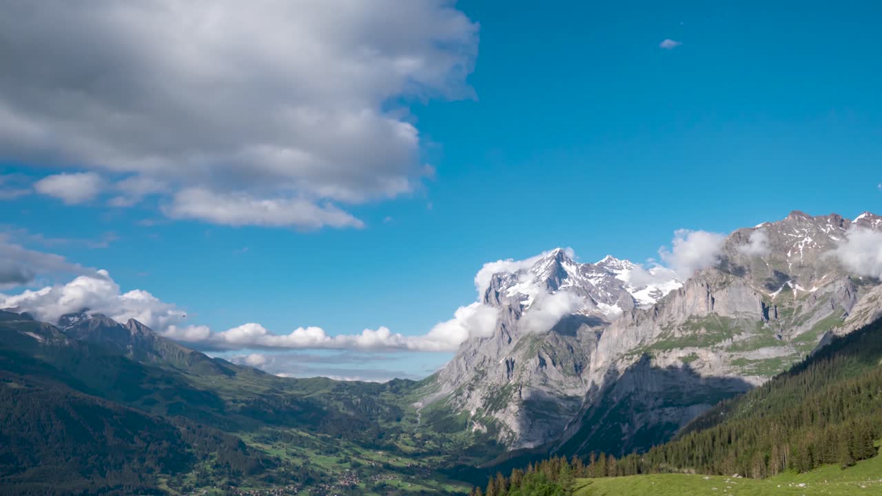Vue imprenable de Grindelwald en Suisse, des nuages défilant au-dessus du Wetterhorn, en accéléré.