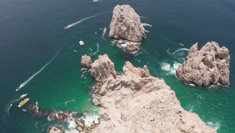 Vista-Aérea-De-Formaciones-Rocosas-En-El-Océano-Con-Barcos