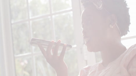 african american woman speaks into her phone, excitement evident