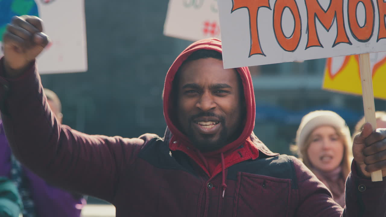 grupo de manifestantes con pancartas cantando consignas en la marcha de manifestación contra el cambio climático