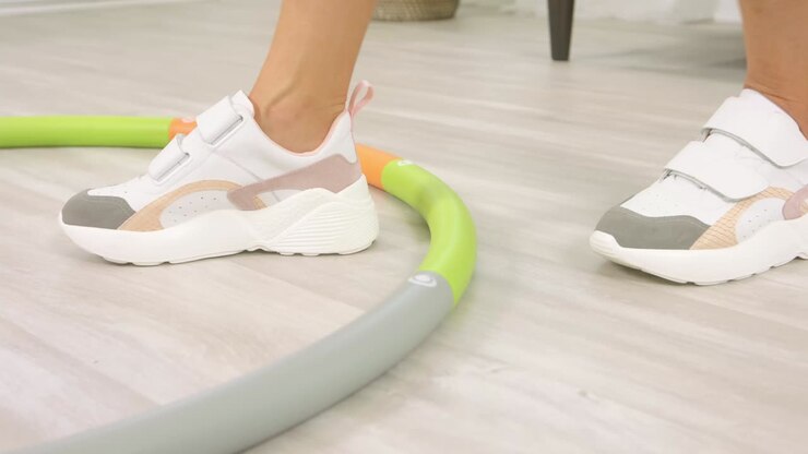 Una bella ragazza con un fisico attraente fa girare un grande cerchio in vita