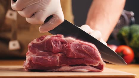 chef cutting raw pork chop