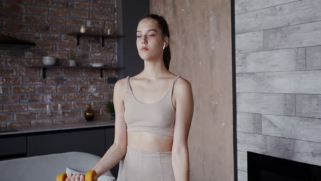 woman working out at home with dumbbells