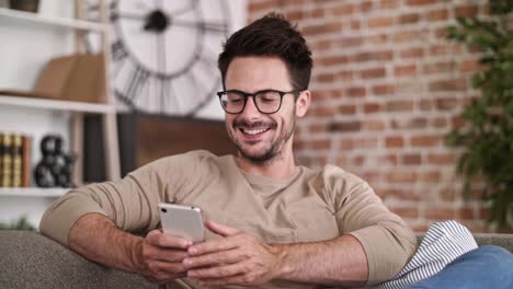 hombre de negocios alegre usando teléfono móvil en la oficina de su casa