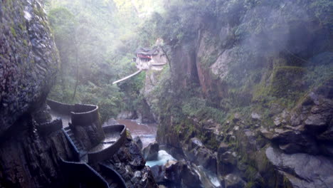 misty view of baños' waterfalls and natural pools with a spiraling staircase, enveloped in lush greenery