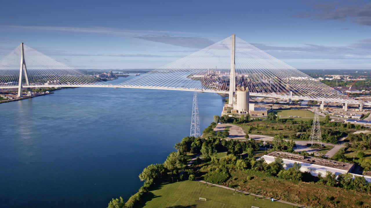 Drone moves across the newly built Gordie Howe Bridge toward industrial zones near the water