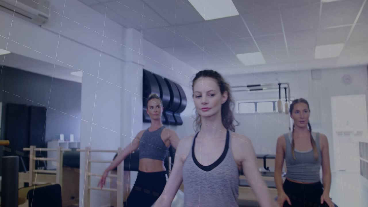 Fitness coach moving behind front woman, fixing arm alignment while bars overlaying frame