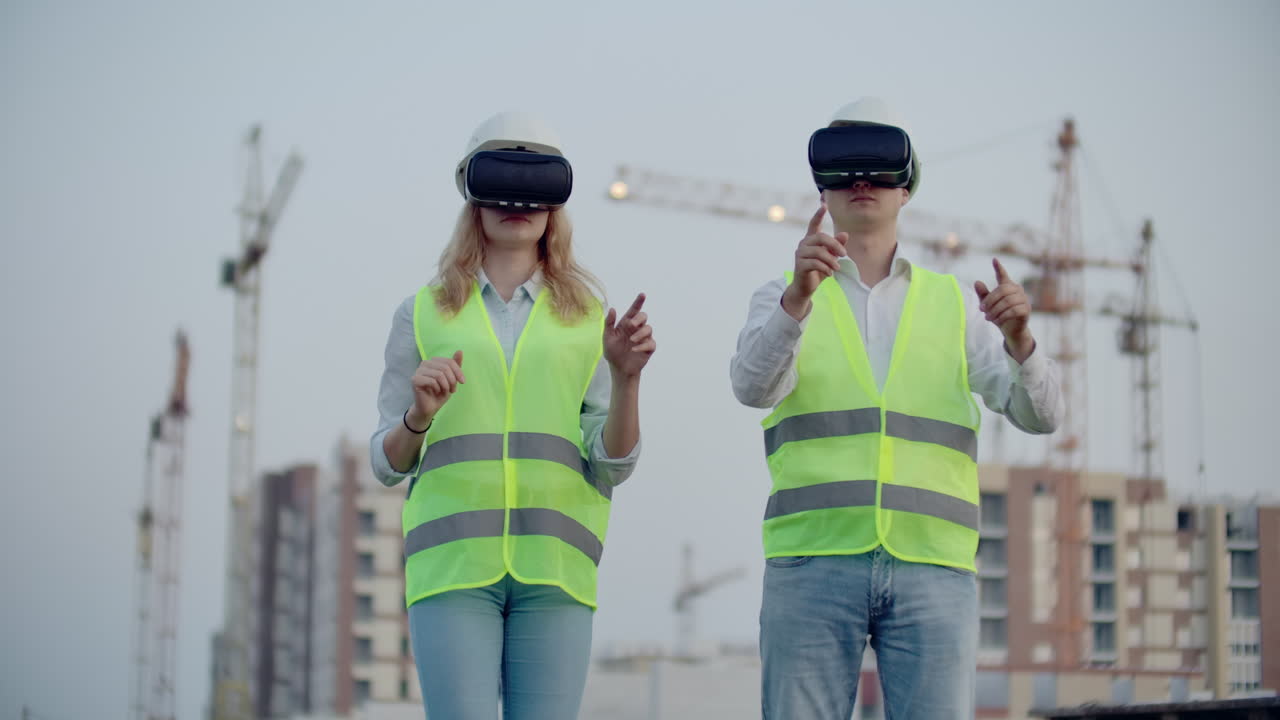 dos gerentes del futuro en el sitio de construcción usan gafas de realidad virtual en el fondo de edificios y grúas mueven sus manos y hacen clic en los iconos.