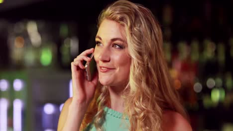 Smiling-woman-on-phone-in-bar-