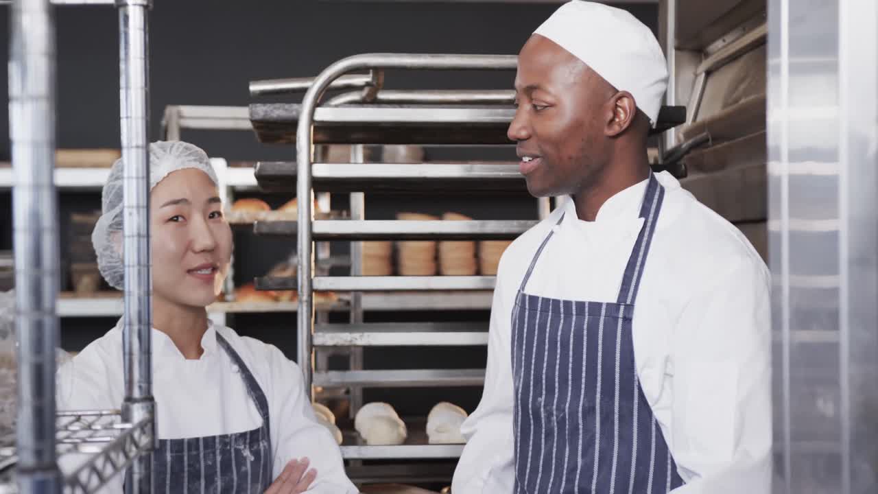 Retrato de padeiros diversos e felizes na cozinha da padaria, com os braços cruzados em câmera lenta.