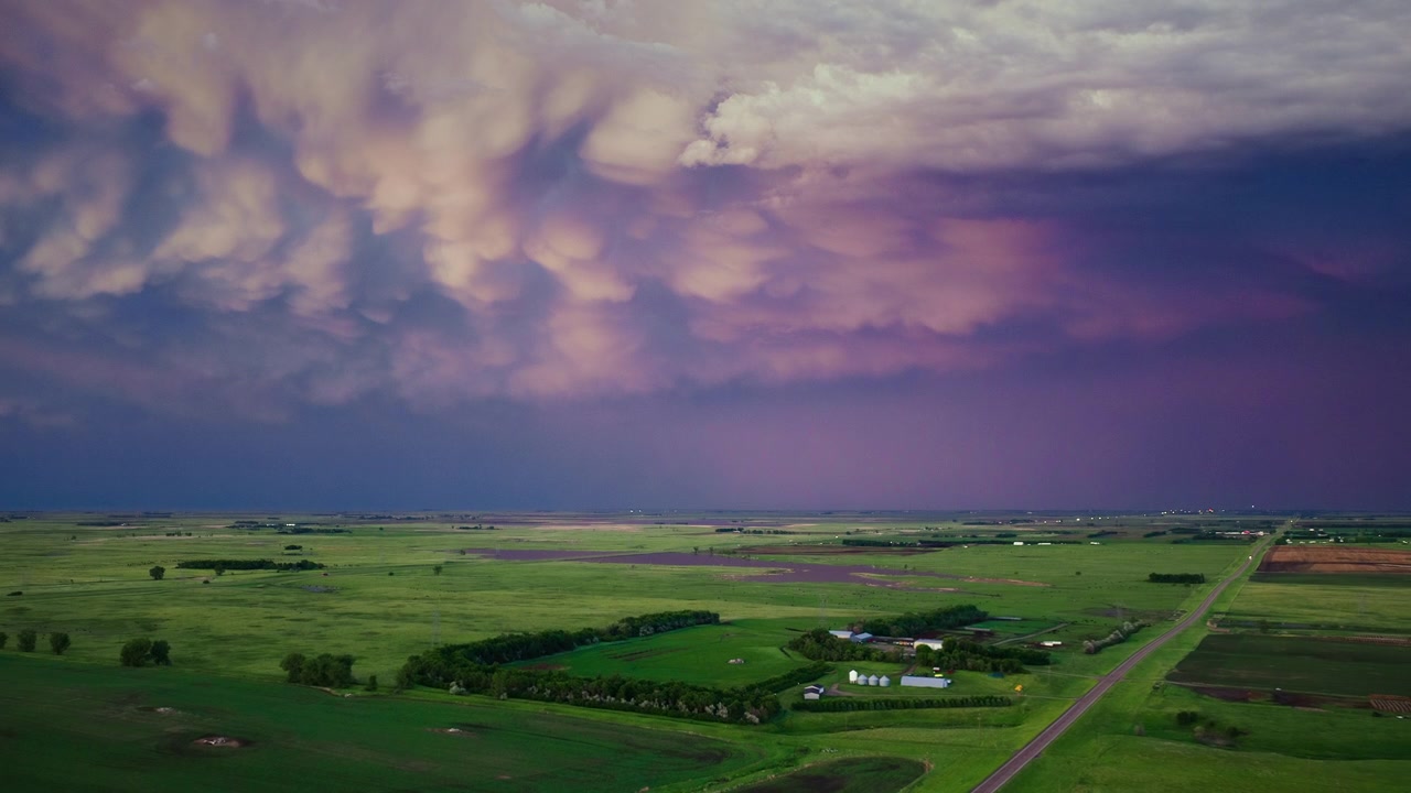 4k drönarvy över färgglada stormmoln vid solnedgången och blixtar