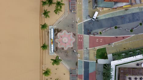 Bird's-eye-wide-shot-of-the-center-plaza-at-the-touristic-Tambaú-beach-boardwalk-in-the-tropical-beach-capital-city-of-Joao-Pessoa,-Paraiba,-Brazil-with-people-gathering-for-pictures-at-the-sign