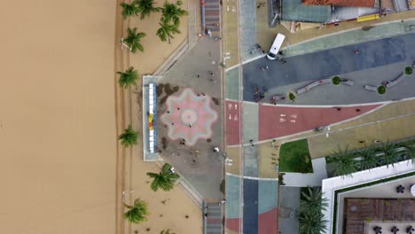 bird's eye wide shot of the center plaza at the touristic tambaú beach boardwalk in the tropical beach capital city of joao pessoa, paraiba, brazil with people gathering for pictures at the sign
