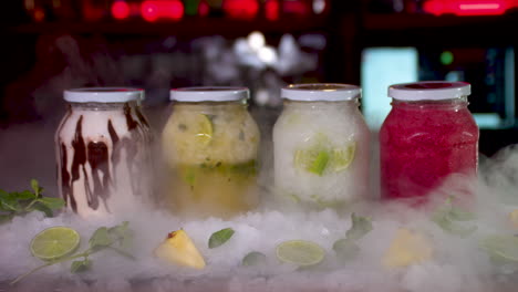 dry ice reveal of colourful frozen smoothie jars on bar