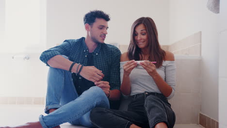 pareja celebrando el resultado positivo de la prueba de embarazo en casa