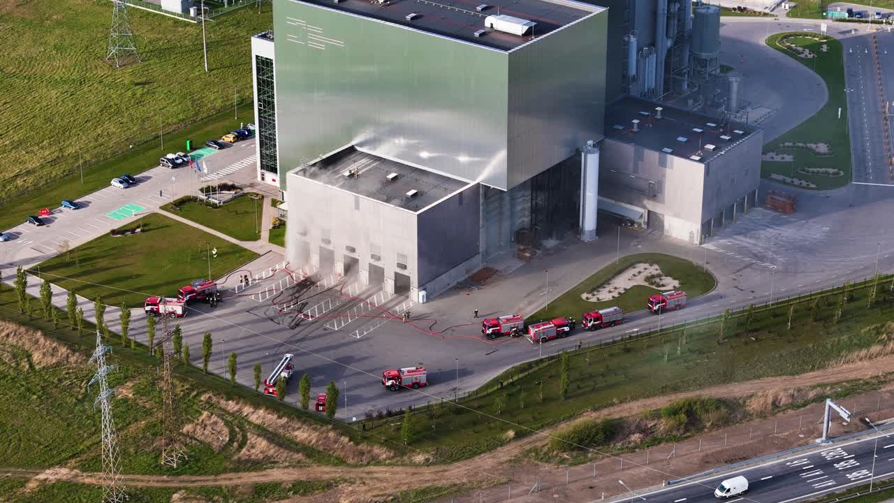 Aerial view of fire crews working at Kaunas cogeneration power facility, with visible smoke and urgency in movement