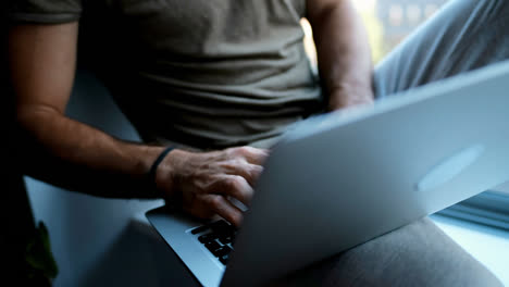 man using laptop in living room 4k