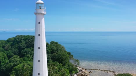 aerial of white lighthouse on remote tropical island in belitung indonsia on sunny summer day