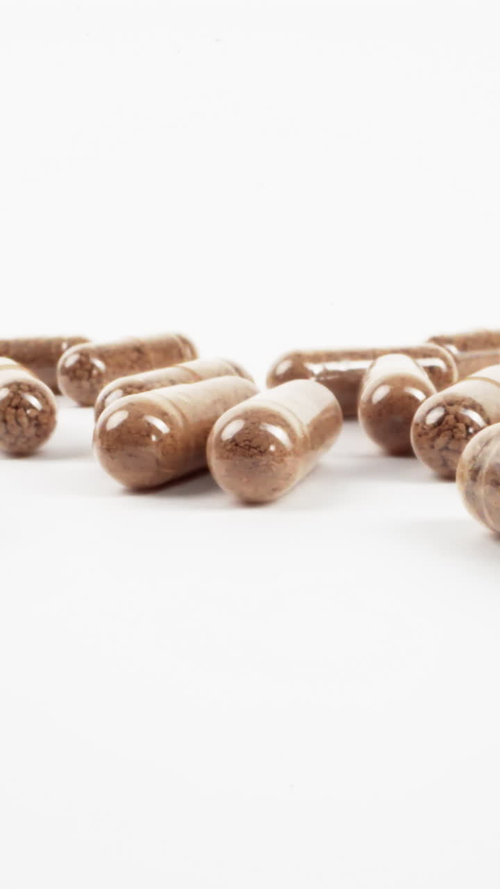 cápsulas de hierbas esparcidas con rellenos naturales sobre un fondo blanco limpio