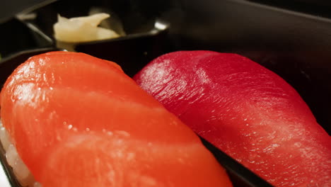 salmon and tuna nigiri in a takeout box