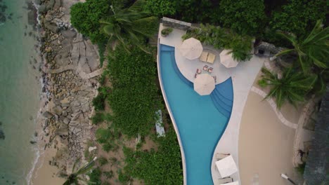 Bird-eye-aerial-showcasing-villa-at-mesmerizing-coastline-in-Huatulco,-Mexico