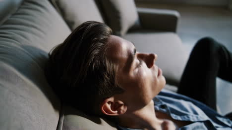 man relaxing on sofa with city view