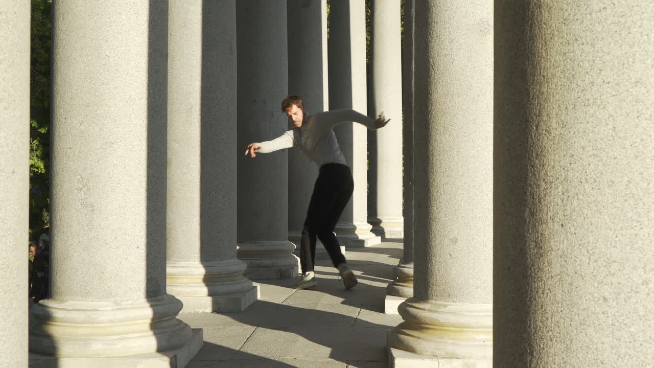young group dancing choreography between tall columns