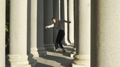 young group dancing choreography between tall columns