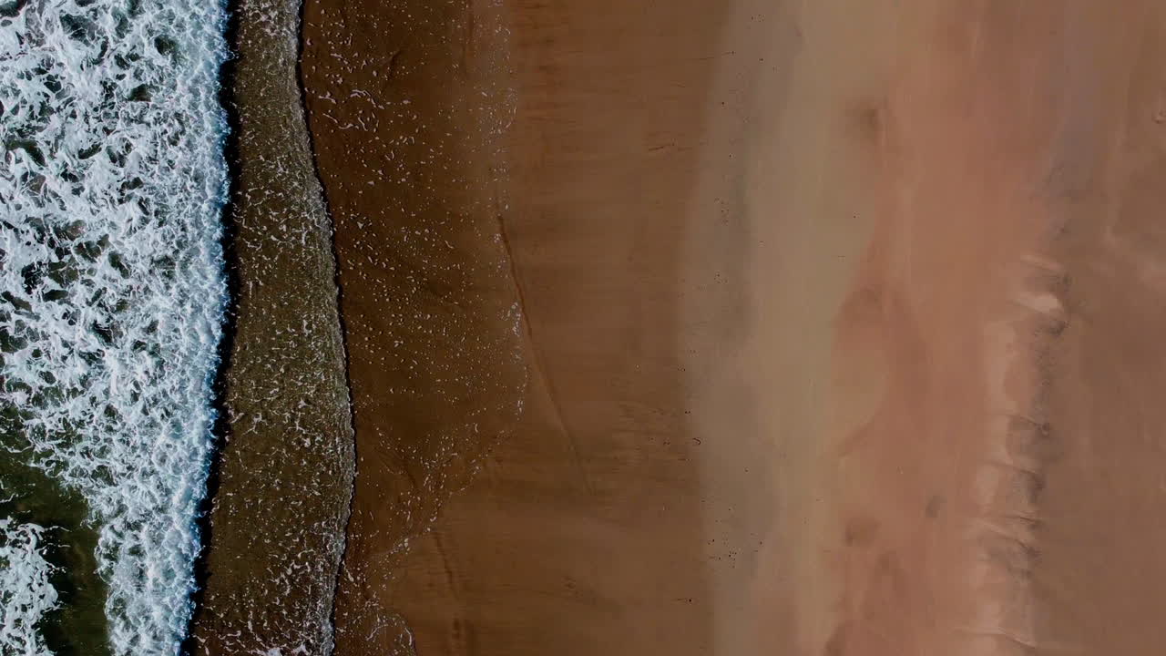 Bird's eye view of the ocean crashing on the sandy shore, Kaiaua Bay, New Zealand