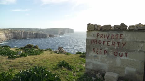 stone shed near mediterranean sea with private property keep out written on the wall