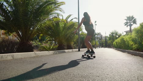 amidst palm trees, a young woman rides a longboard in slow motion during summer, her shorts and sneakers completing the vibrant scene