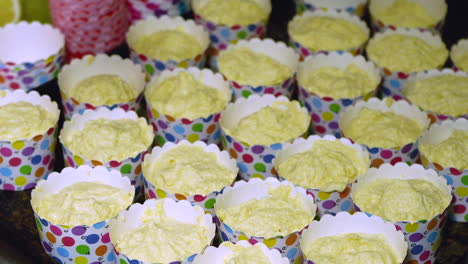 Filling-cupcake-pans-with-delicious-lemon-batter,-using-and-ice-cream-spoon