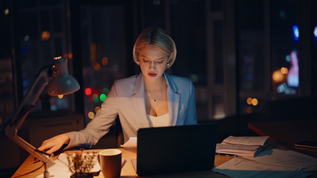 Successful employee talking virtual conference at dark office. Smiling blonde