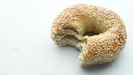 bagel de sésamo comido a mitad