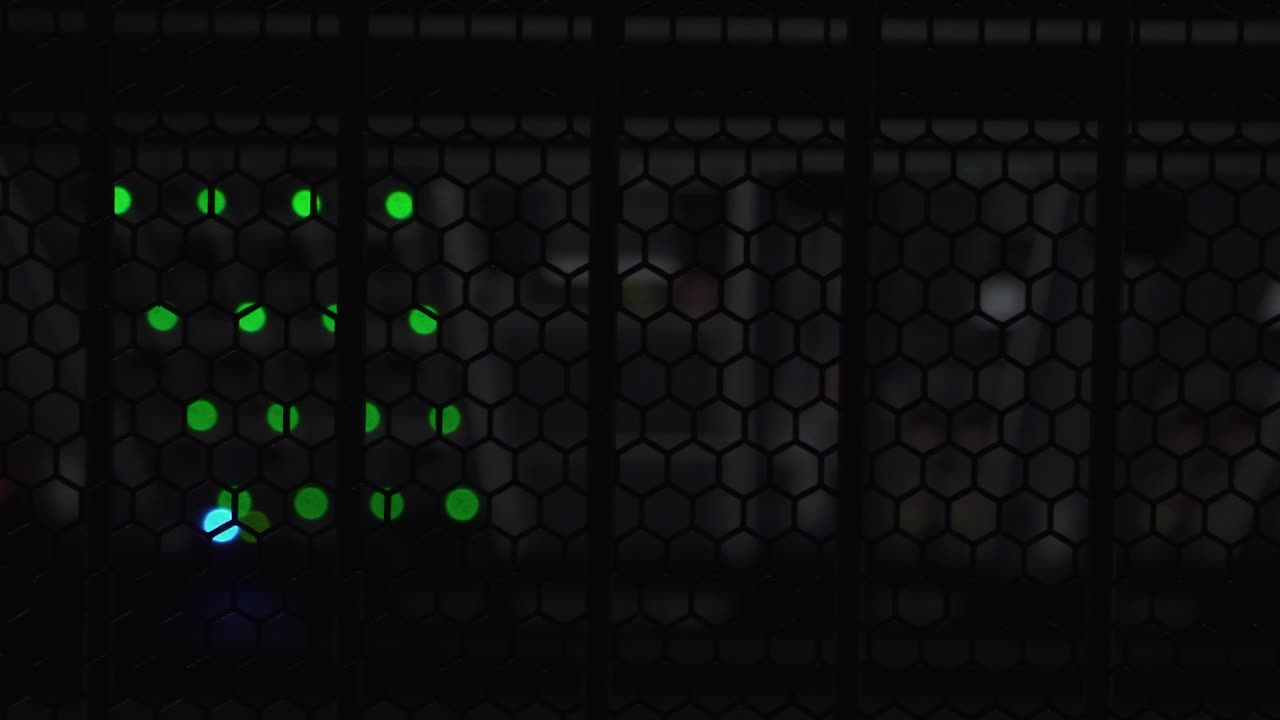 verticale weergave van lamp die gloeit in een donkere datakast boven een opslagserver met wazig groen licht