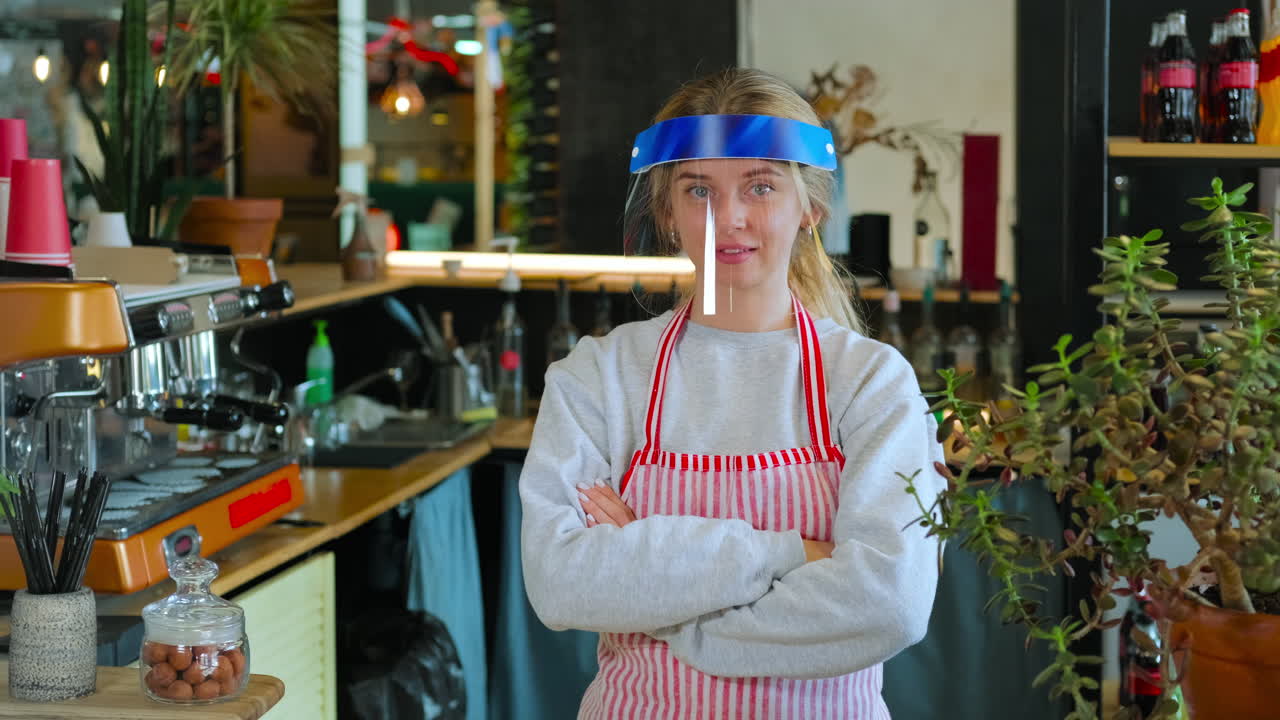barista en una cafetería con un escudo facial