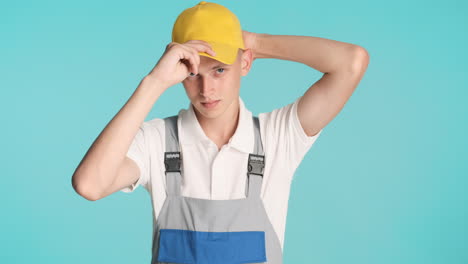 joven constructor poniéndose la gorra amarilla