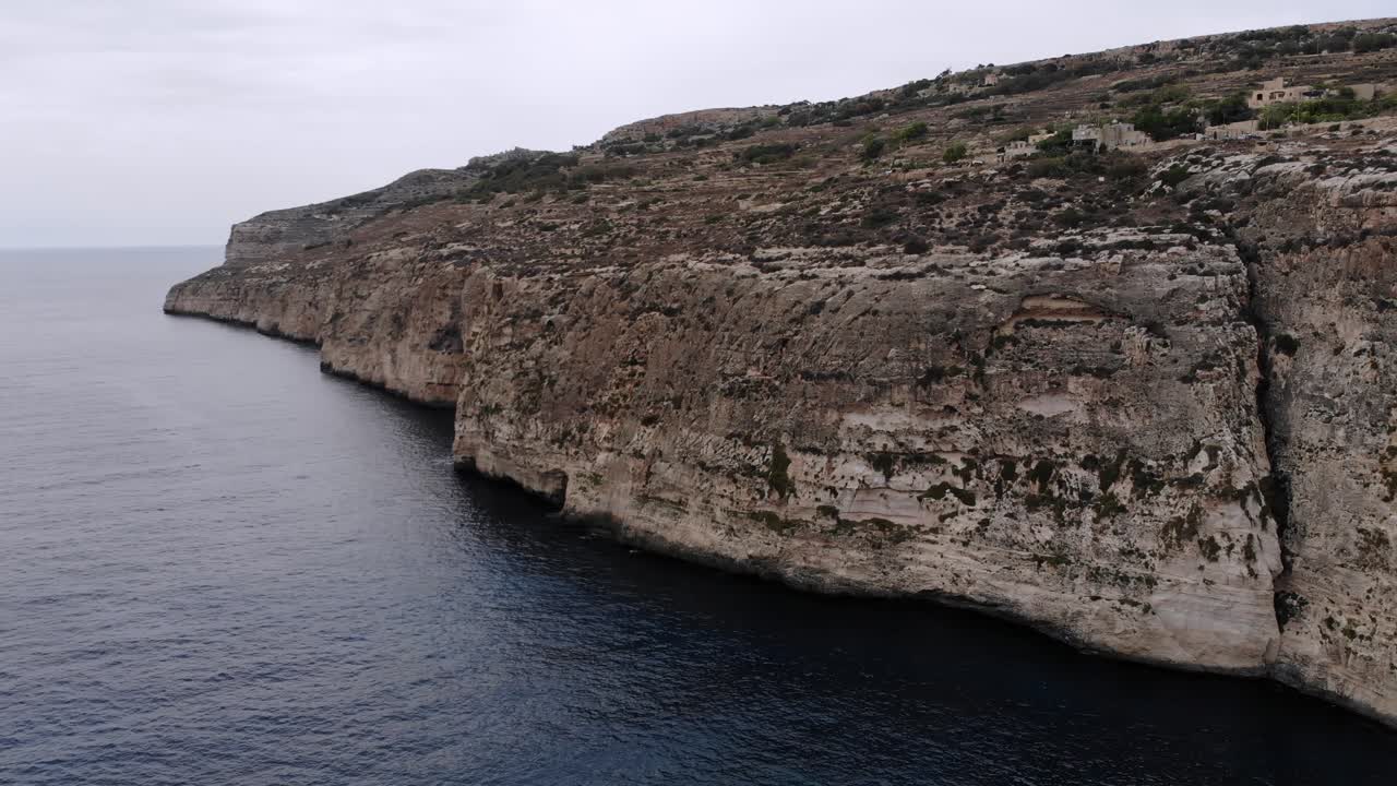 Aerial drone video from Malta, flying around the Xaqqa Cliffs on a cloudy day