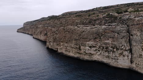 aerial drone video from malta, flying around the xaqqa cliffs on a cloudy day