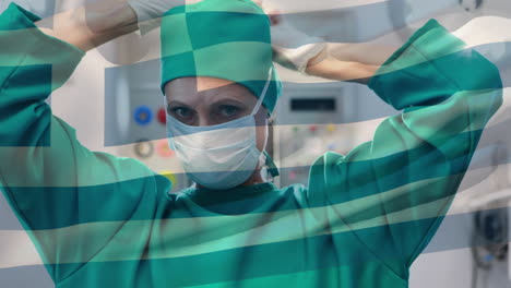 animation of flag of greece waving over female surgeon in operating theatre