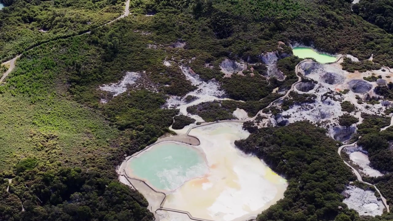 Rotorua, Bay of Plenty, Selandia Baru, pemandangan udara kolam panas geotermal, lanskap vulkanik, dan formasi mineral yang dikelilingi vegetasi asli