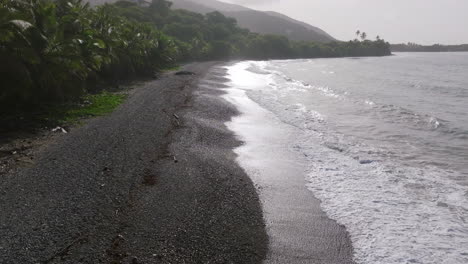 aerial footage slowly and closely following the beach and coastline in the line of the sun in southern puerto rico on a rocky beach