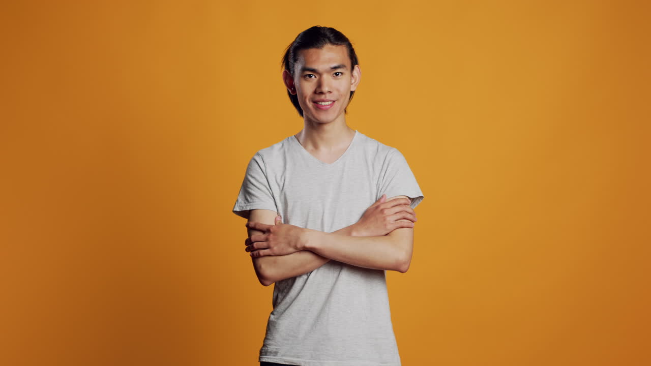 Casual asian man posing on studio background