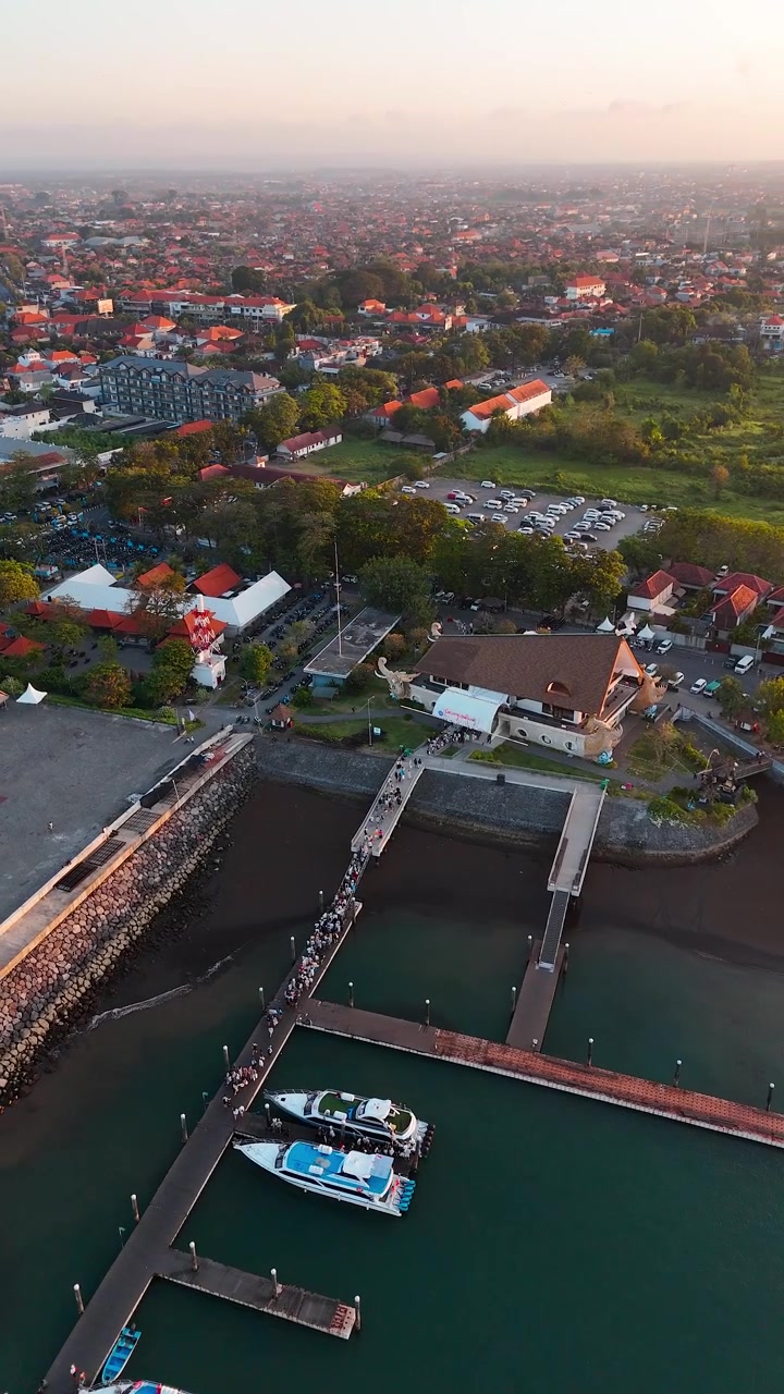 Verticale, aerea: porto turistico di Sanur al tramonto con l'Oceano Indiano a Bali, Indonesia, ripresa orbitale con drone