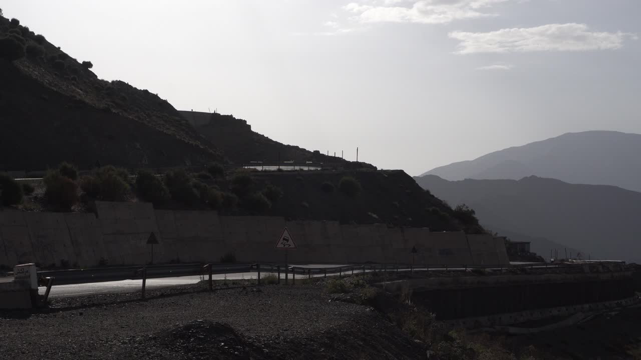 A small road in the mountains under a sky with a few clouds. It is truly a breathtaking scene