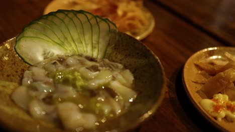 close-up of japanese dish with cucumber garnish