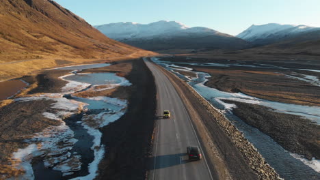 Auto-Einer-Leeren-Straße-In-Der-Wildnis-Islands,-Vorbei-An-Gletscherbach-Und-Vulkanbergen-An-Sonnigen-Tagen,-Drohnen-Luftaufnahme