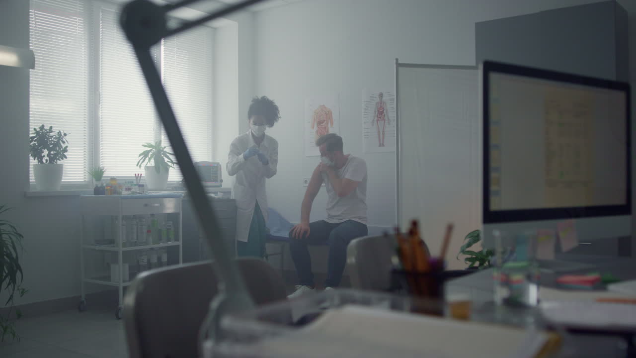 여성 의사가 병원에서 남성을 예방접종하고 있습니다. 의사가 백신 주사를 맞고 있습니다.