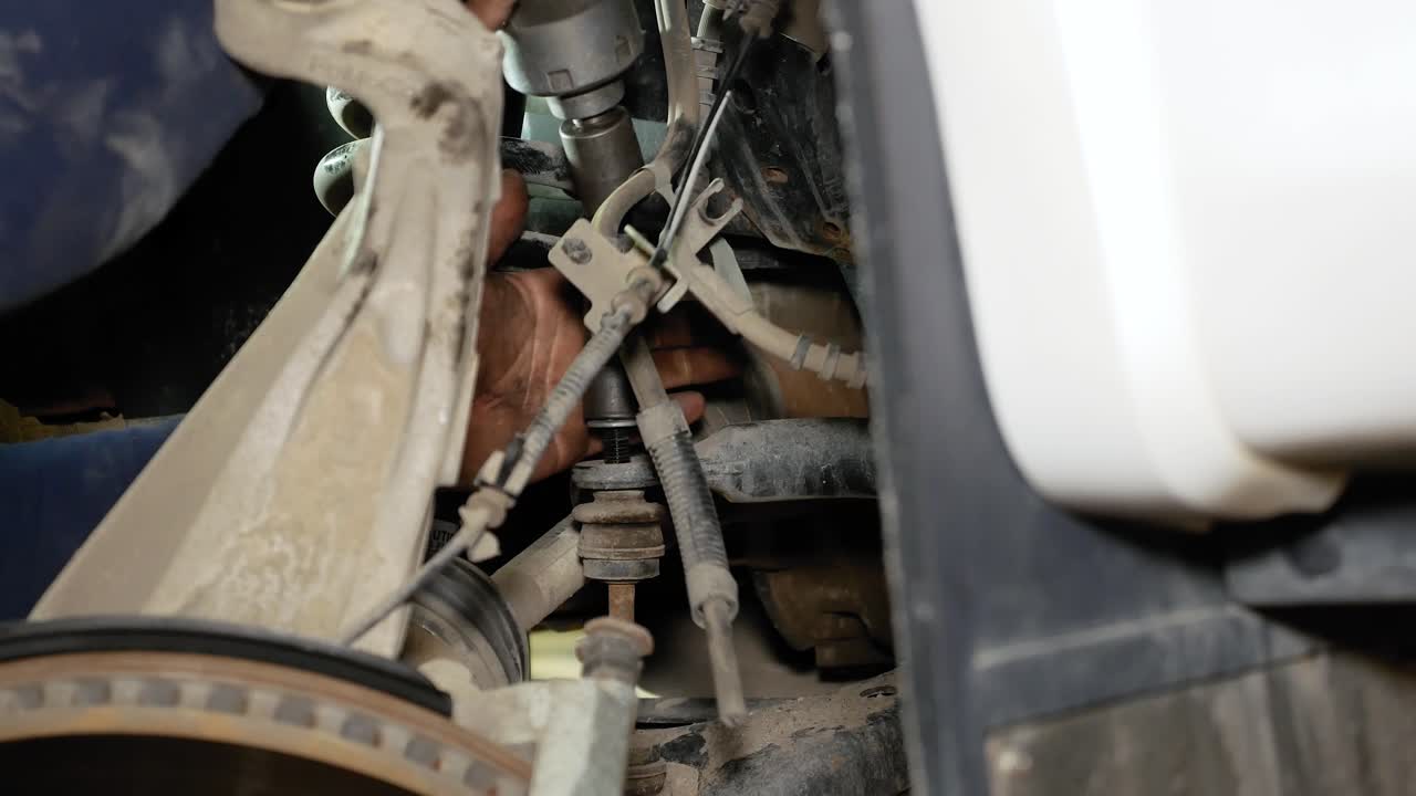 Premium stock video A mechanic using a impact gun to tighten a sway