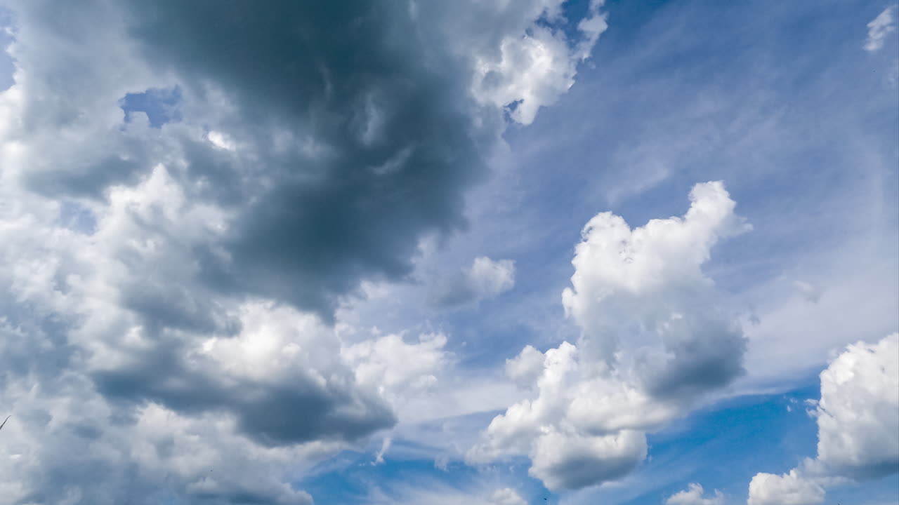 Fluffy clouds transforming at the backdrop of dense cloudscape. Cumulus clouds and spindrift clouds in the atmosphere timelapse.